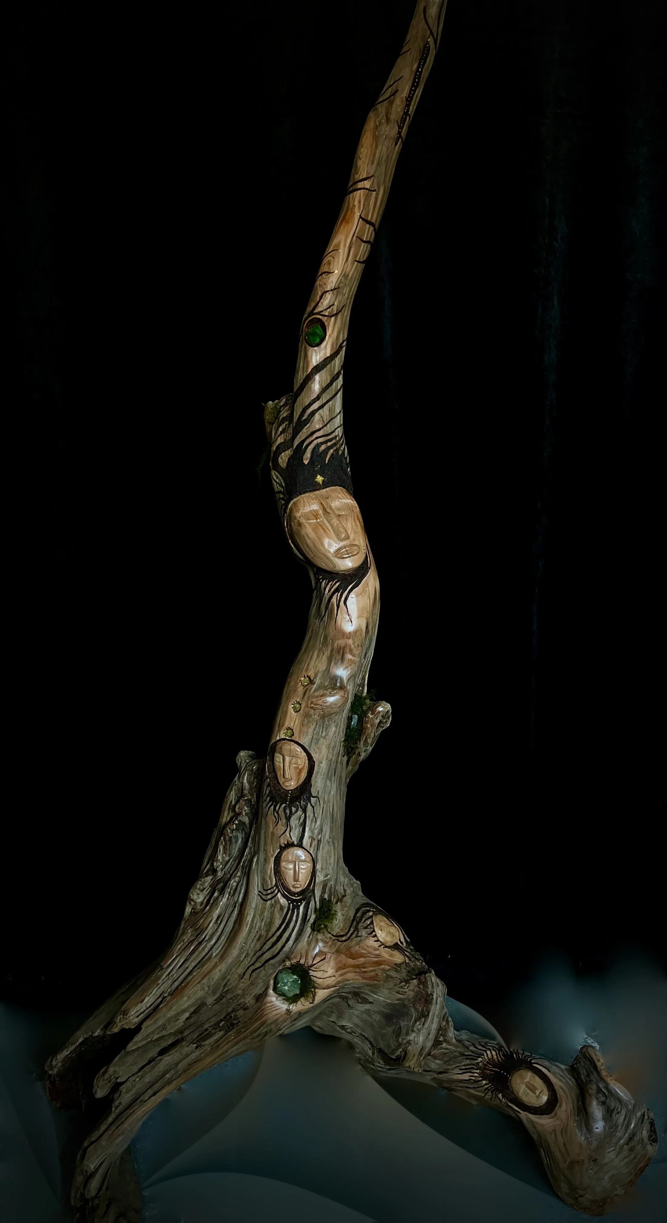 A wooden sculpture featuring multiple faces