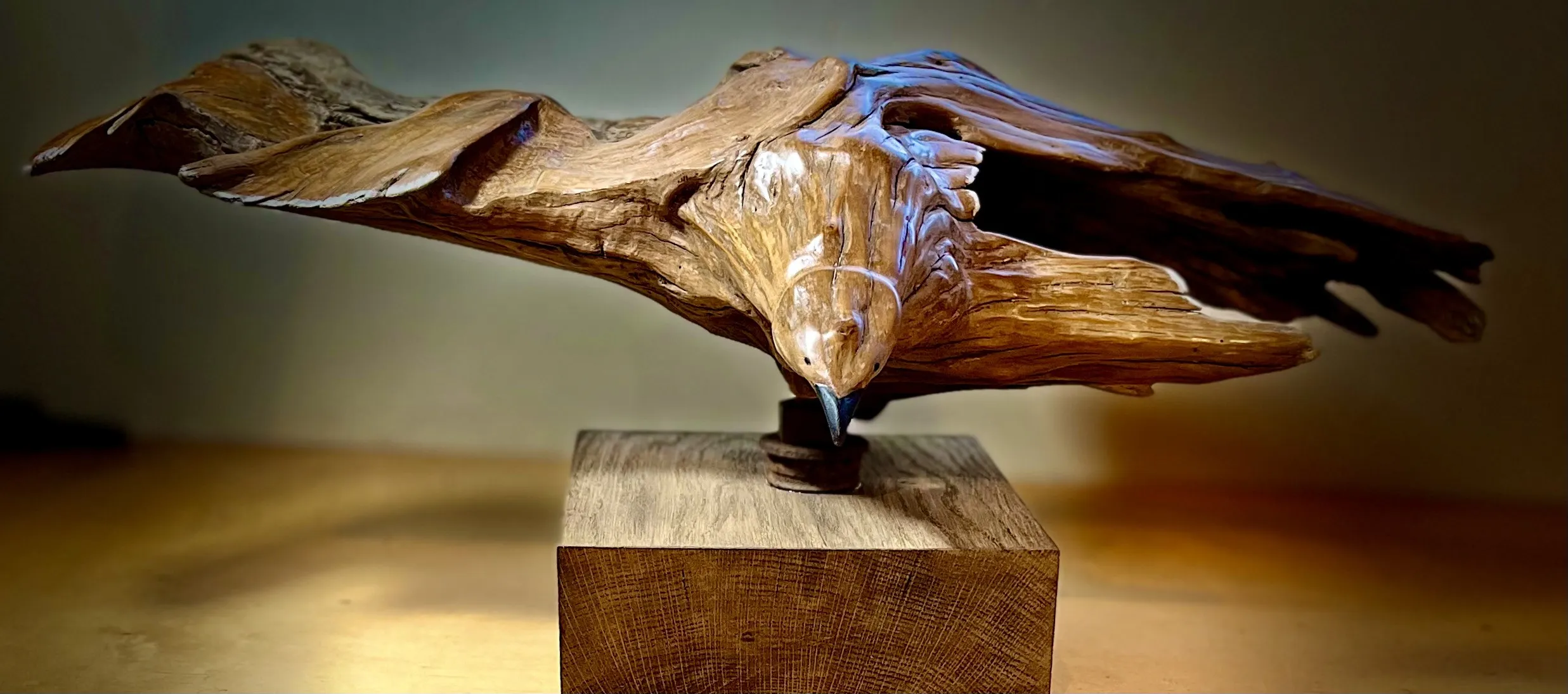 A wooden bird sculpture perched on a wooden block