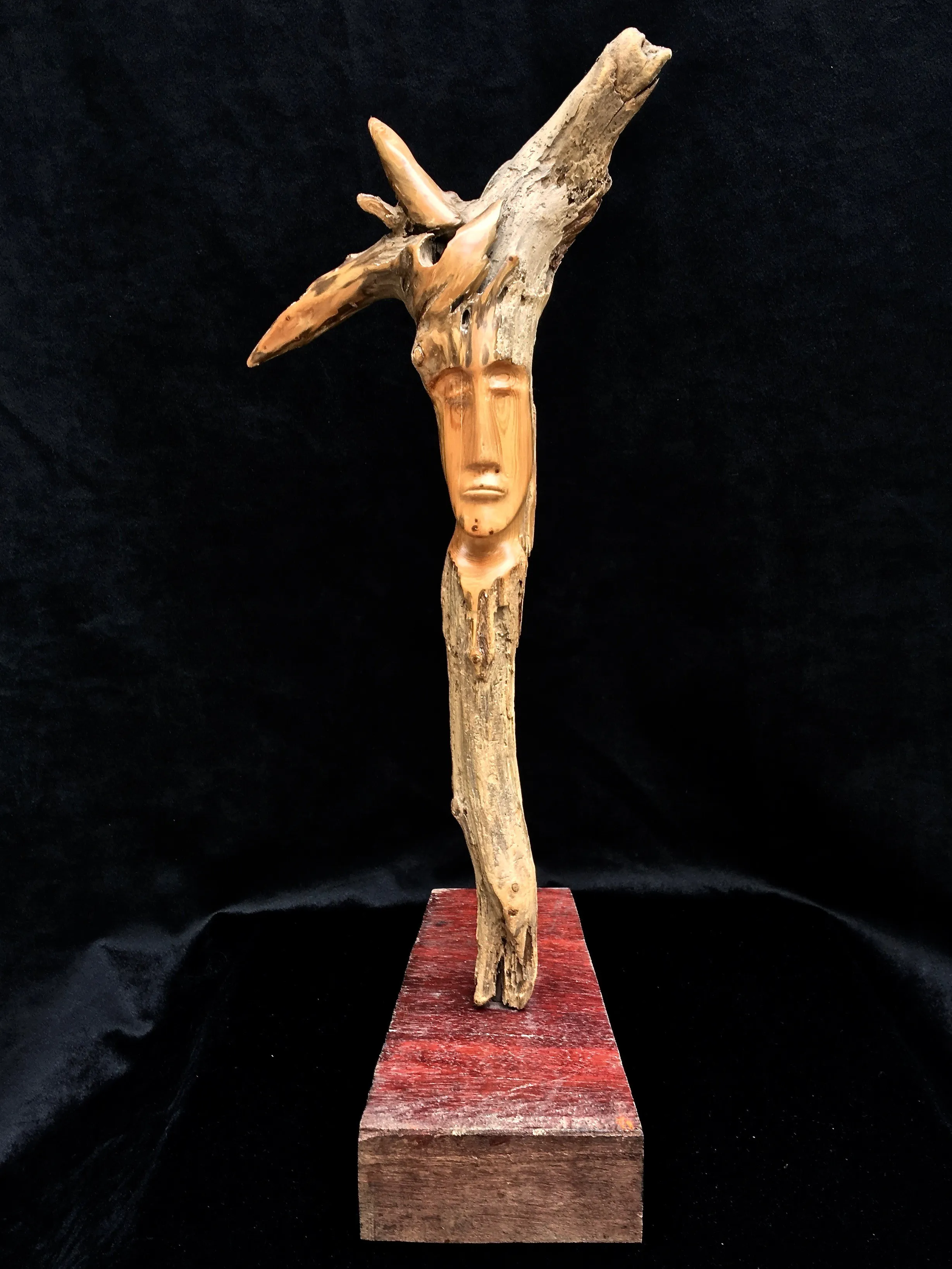 A wooden sculpture of a man's face, intricately carved