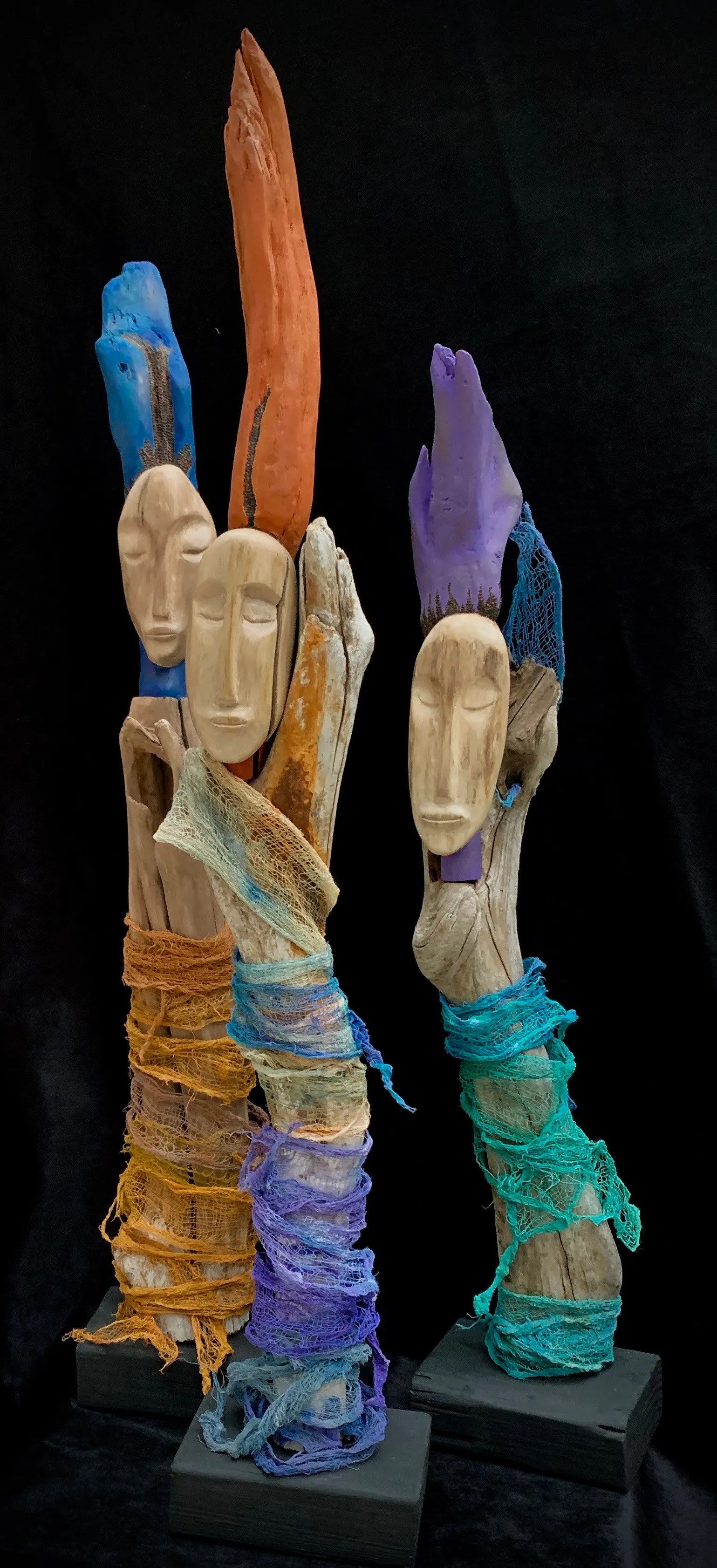 Three vibrant sculptures of people, each with unique and colorful hair