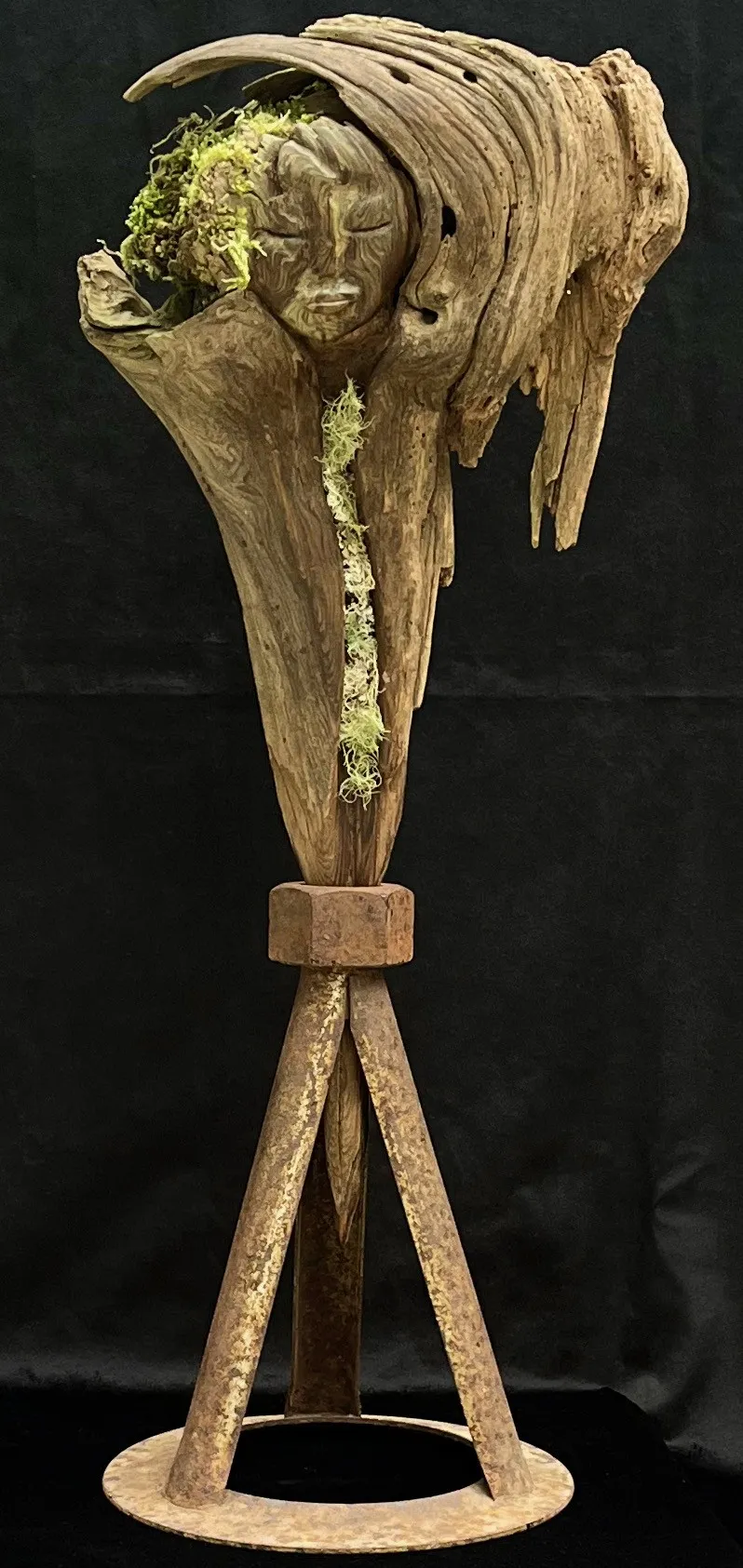 A wooden sculpture of head displayed on a simple wooden stand