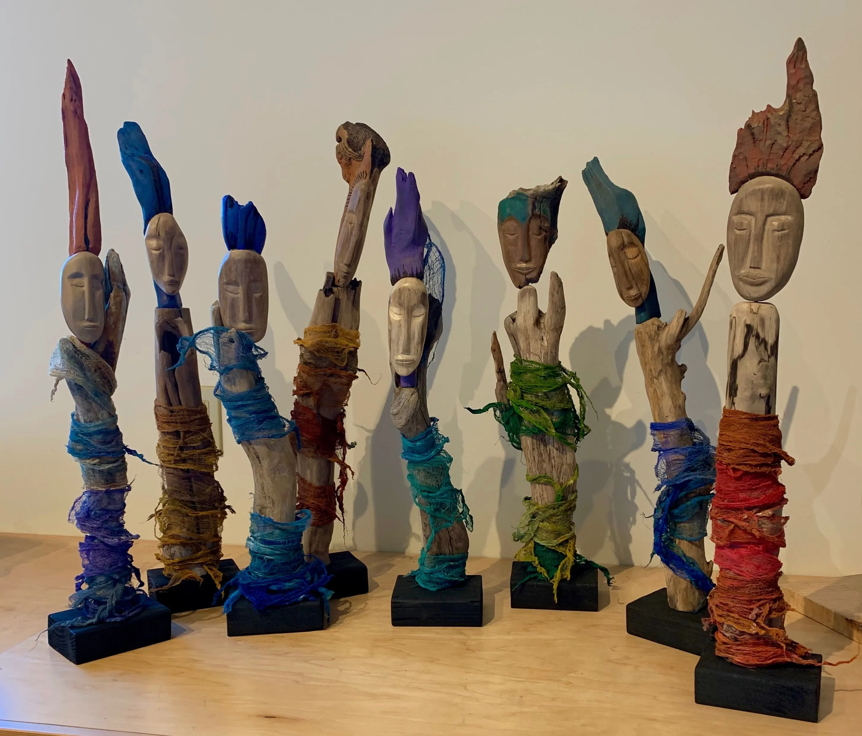 A collection of wooden figures with vibrant, colorful hair