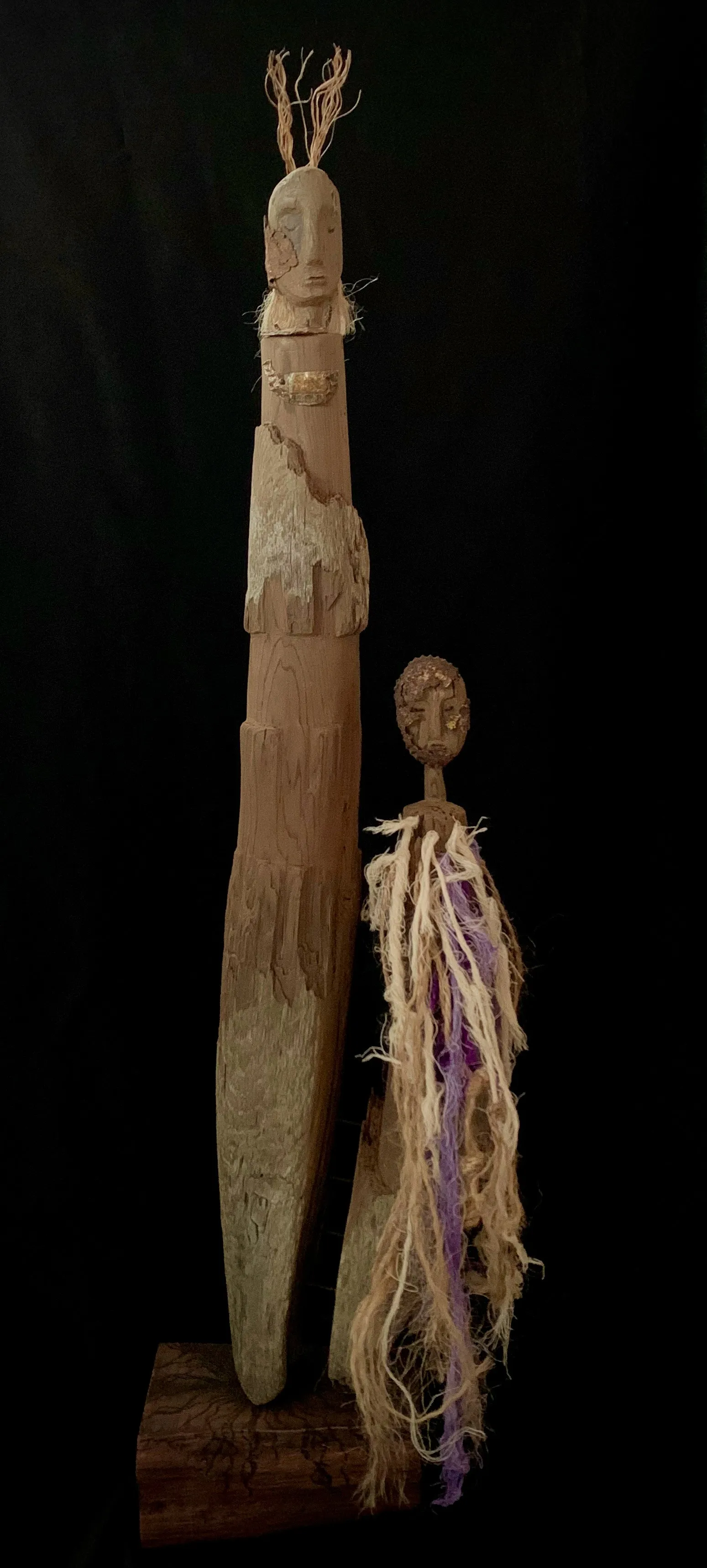 A wooden sculpture featuring a mother and a child